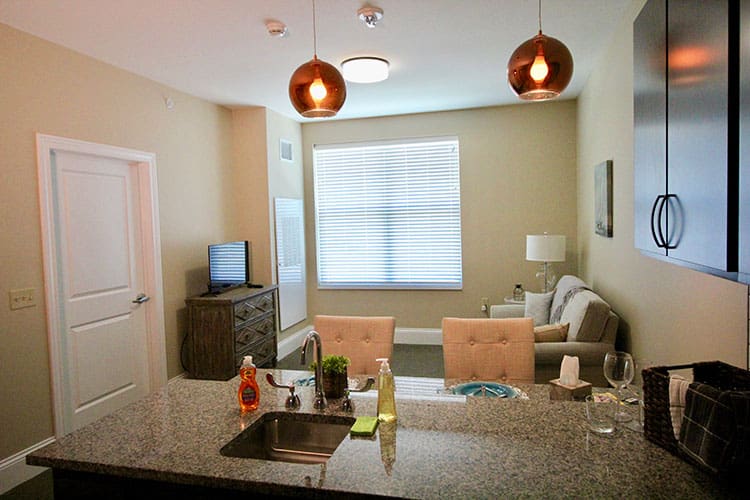 Charter Senior Living of Oak Openings, IL resident suite kitchenette and living room with modern lighting
