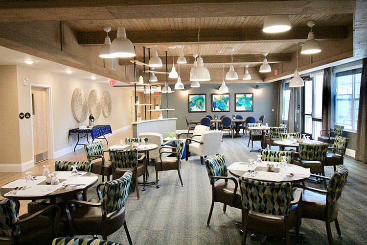 Charter Senior Living of Oak Openings, IL formal dining room set with glassware, silverware, and white placemats