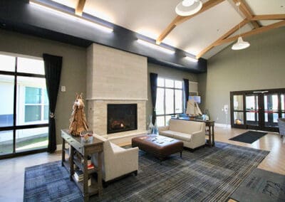 Charter Senior Living of Oak Openings, IL main lobby with two couches and a ottoman around a lit fireplace